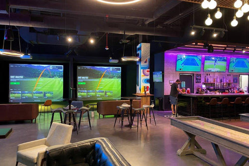 Five Iron Indoor Golf Center Setup with Seating and Bar Area.