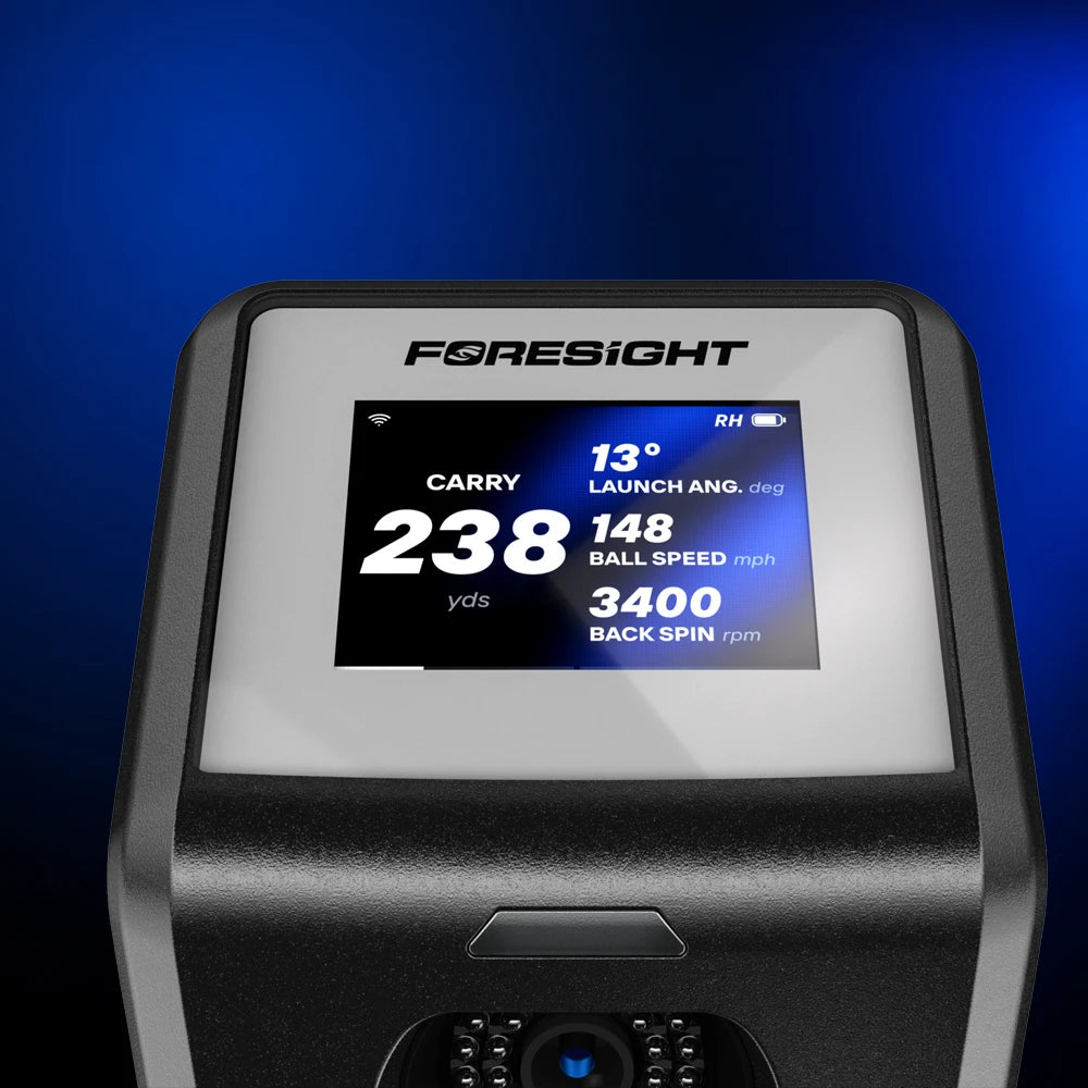 A close-up of a Foresight GC2 launch monitor color screen showing a digital carry distance, launch angle, ball speed, and back spin data against a dark blue background.