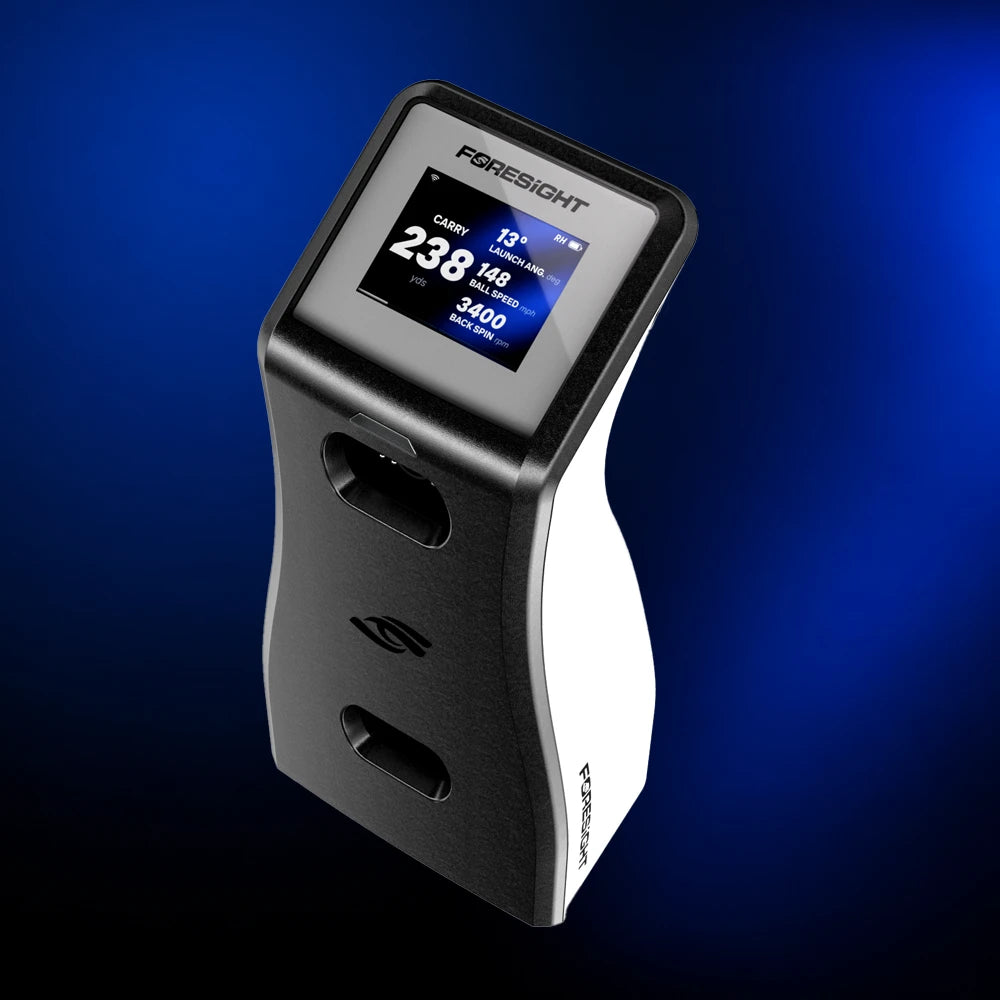 A Foresight GC2 golf simulator with a black and white body, featuring an active color display screen, shown against a dark blue gradient background.