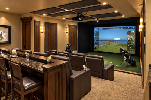 TruGolf Apogee home theater and golf simulator  featuring two rows of brown leather theater seats with a third row bar with chairs looking into a golf course on the screen.