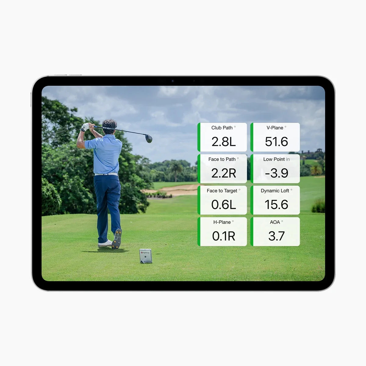 A tablet device displaying golf swing analytics with a golf course scene and numerical data overlays, shown on a plain light background.
